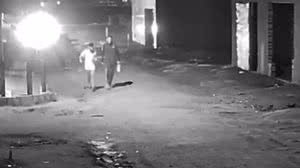 À esquerda, vítima usava camisa clara e foi surpreendida com diversos disparos na cabeça pelo homem vestido de preto - Reprodução