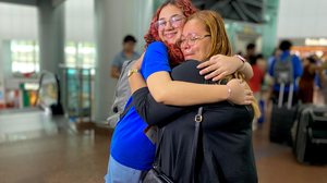 A estudante Eduarda Bitencourt ao lado da mãe, Luzia da Conceição, que não conteve a emoção no momento do embarque - Gabriel Amorim / TNH1