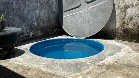 Estrutura da caixa d'água adaptada no solo da casa, como uma espécie de piscina. Há degraus que levam ao acesso do deque improvisado - Reprodução