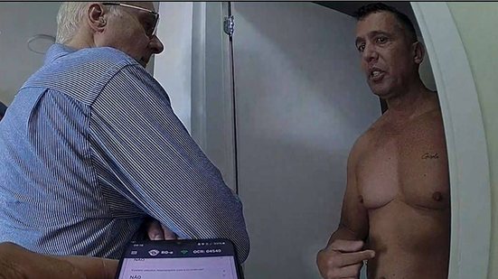 O tenente-coronel da PM Geraldo Leite Rosa Neto (sem camisa) no apartamento onde sua esposa, a soldado Gisele Santana, havia acabado de ser baleada na cabeça; na imagem, ele aparece ao lado de um desembargador do TJ-SP - Reprodução / Polícia Militar