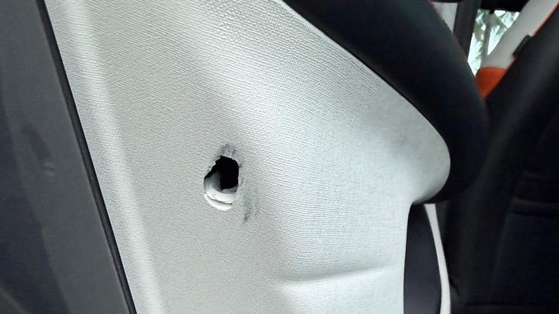 Porta do veículo, aparentemente um BYD Dolphin Plus, ficou danificada com a marca do tiro. - Cortesia ao TNH1
