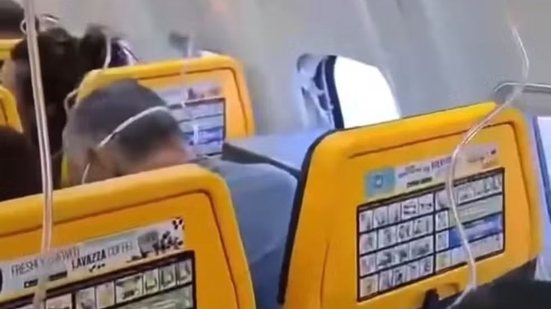 Passageiro, com a cabeça baixa e com máscara de oxigênio, após incidente - Reprodução / X