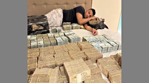 O ex-deputado TH Joias posa deitado numa cama repleta de dinheiro, em maio de 2024; imagem consta de denúncia contra ele - Reprodução / MPF