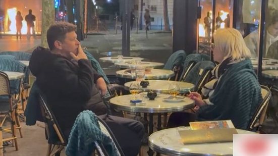 Casal aproveita drinque em café enquanto protestos tomam Paris\u003B imagem repercute