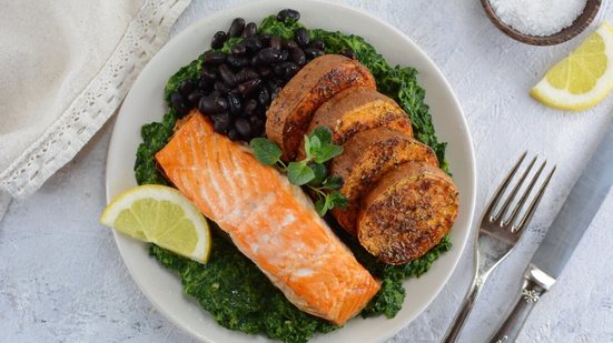 Salmão grelhado com batata-doce assada, espinafre refogado e feijão-preto (Imagem: Azra H | Shutterstock)