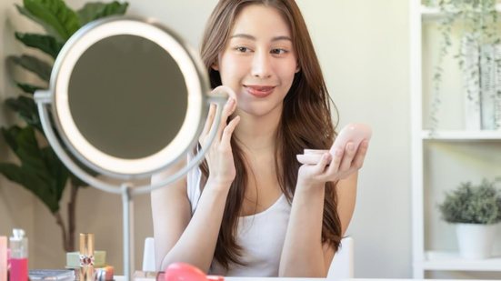 Diante de altas temperaturas, aumento da oleosidade e incidência direta de sol, aplicar cada item na ordem certa garante melhor desempenho da maquiagem (Imagem: Pormezz | Shutterstock)