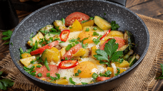 Ovos com legumes na frigideira (Imagem: Timolina | Shutterstock)