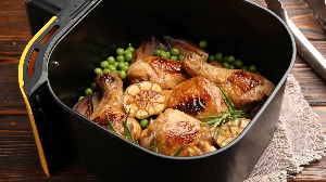 Frango assado na air fryer com alho e ervilhas (Imagem: New Africa | Shutterstock)