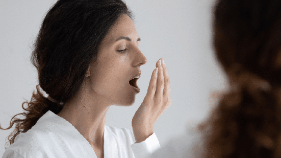 Sangramento gengival, acúmulo de resíduos na língua e redução da saliva são alguns fatores que podem favorecer o mau hálito (Imagem: fizkes | Shutterstock)
