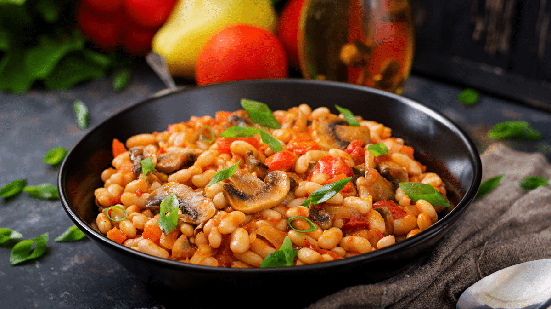 Feijão-branco com cogumelos e tomates (Imagem: Timolina | Shutterstock)