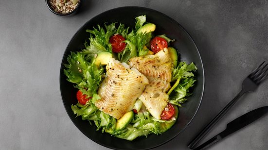 Peixe grelhado com salada verde e abacate (Imagem: Maria Tebriaeva | Shutterstock)