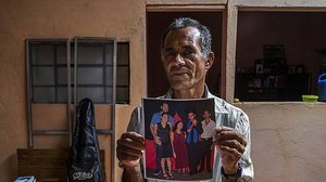 João Antonio Ribeiro, 61, mostra foto do filho Cleiton comemorando a formatura do ensino fundamental | Folhapress