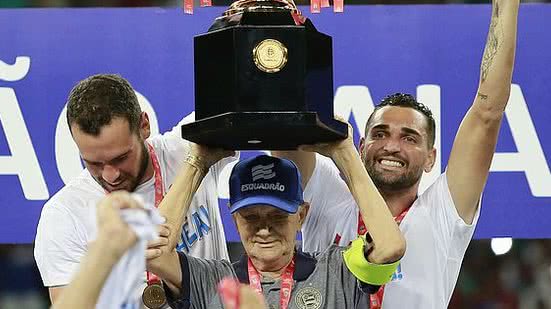 Adherbal Amaral, de 81 anos, funcionário do clube há mais de 42, levanta a taça de campeão na Arena Fonte Nova | Felipe Oliveira / EC Bahia