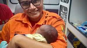 A sargento Anielly Oliveira segurando no colo o bebê de apenas 30 dias, logo após salvá-lo no quartel do Grupamento de Incêndio em Maceió | Divulgação / Corpo de Bombeiros