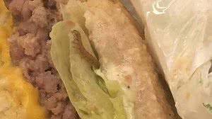 A advogada fez uma foto da larva no meio do sanduíche | Reprodução Facebook