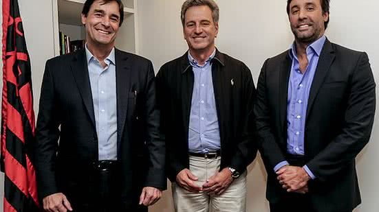 Gabriel Pentagna Guimarães (diretor presidente do BS2), à esquerda, e Rodrigo Pentagna Guimarães (vice-presidente comercial do BS2), à direita do presidente Rodolfo Landim | Marcelo Cortes / Flamengo