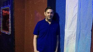 Karlos posa ao lado da bandeira G0Y, à entrada do bar; a inauguração está marcada para o dia 24 | UOL