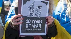 Mulher segura uma placa mostrando 10 anos de guerra desde a anexação da Crimeia pela Rússia em um comício pela Ucrânia no segundo aniversário da invasão russa da Ucrânia na Times Square em fevereiro, na cidade de Nova York | Thenews2 / Folhapress