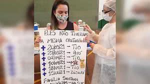 Adolescente levou um cartaz com as datas da morte de familiares, que sucumbiram à Covid-19 sem poder ter acesso à vacina | Foto: Reprodução / Facebook