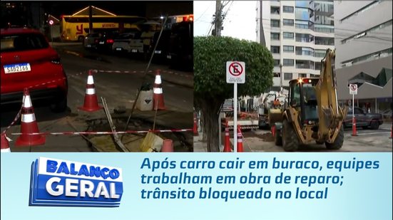 Após carro cair em buraco, equipes trabalham em obra de reparo; trânsito bloqueado no local