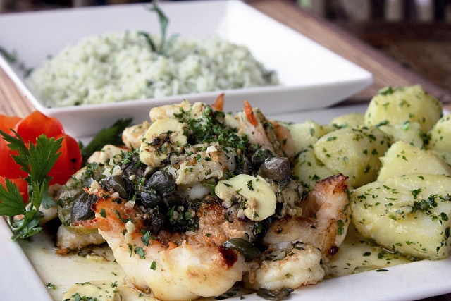 Lagostins são grelhados ao molho de manteiga, cogumelos em lâminas, alcaparras e fatias finas de limão