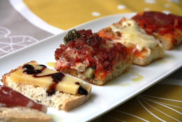 Para começar: pizzas quadradas, pão caseiro, queijo parmesão e presunto de parma