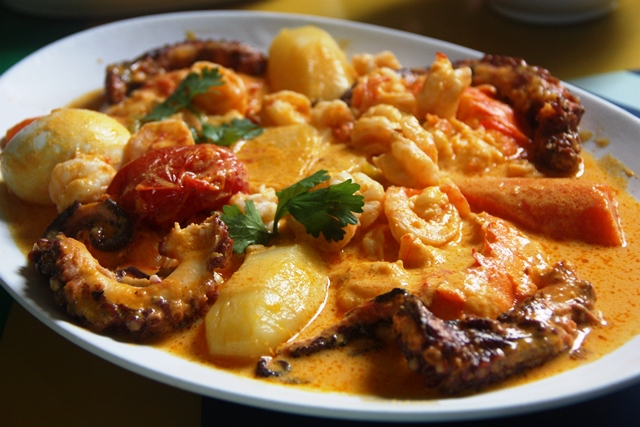 Detalhe da peixada a moda casa: lagosta, polvo, camarão e legumes no leite de coco natural