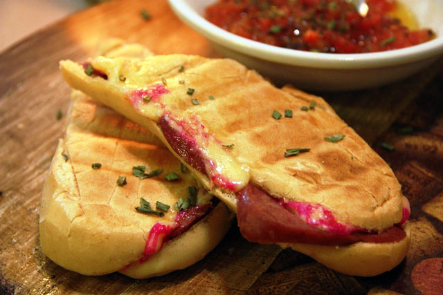 Baquete com linguiça portuguesa e queijo gouda. Destaque molho de tomate no azeite