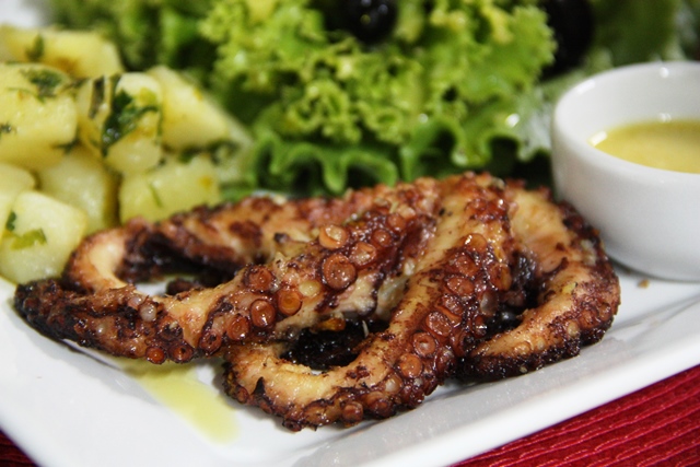 Saladas. A casa também tem receitas leves, a exemplo da salada violeta: mix de folhas verdes, polvo grelhado, azeitonas e batatas sautées. O polvo macio é temperado no sal, alho e salsinha, cozido e depois grelhado no azeite. O fruto do mar de textura macia é acompanhado de batatas, forrando bem o estômago, além, claro, de ótimo paladar. Para escoltar a salada, o molho de mostarda dijon e vinagre de vinho branco.