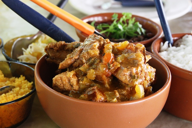 Galinha guisada com fava, salada, arroz e farofa de cuscuz, clássico do Bar do Suruagy
