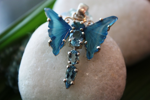 As asas da borboleta são de ágata azul e o corpo, feito com pedras água marinha. Inspiração de Damian