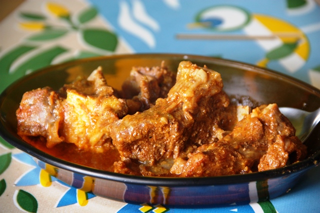 Detalhe do bode guisado e molho encorpado para mistura no inhame ou cuscuz