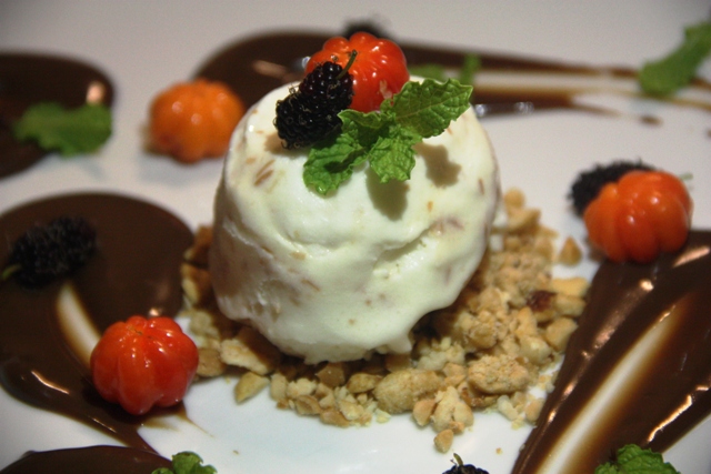 Sorvete com calda de chocolate, farofa de castanha de caju e pitangas
