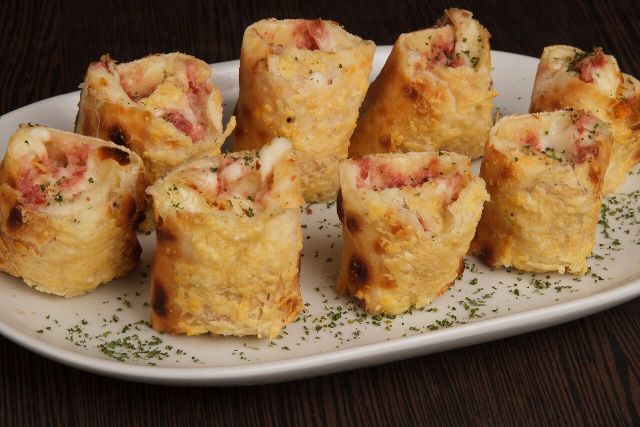 ARMAZÉM GUIMARÃES Enroladinho Calabrês - Massa de pizza gratinada com parmesão, recheada de mussarela, calabresa moída e requeijão cremoso