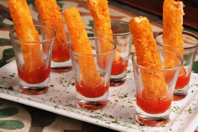 KANOA Palito Provolone - Palitos de provolone empanados em farofa de doritos e frito. Acompanha molho agridoce de acerola levemente picante