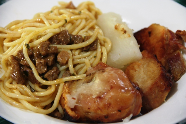 De comer rezando macarrão (caseiro) ao molho com pedaços de carne suína e galetinho. Nota mil