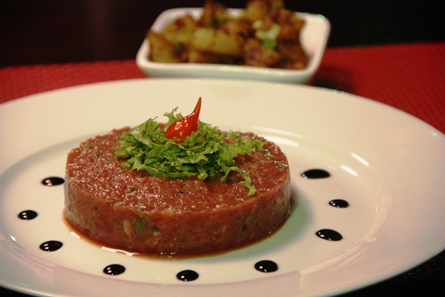 Carne crua bem picada, temperada com sal, pimenta, alcaparras, ketchup, mostarda, salsa e gema de ovo