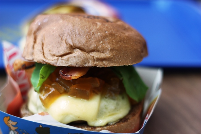 O Hambúrguer Suíno (150g) vem com queijo mussarela, bacon em tiras, rúcula, e o chutney (espécie de geleia) de maçã 