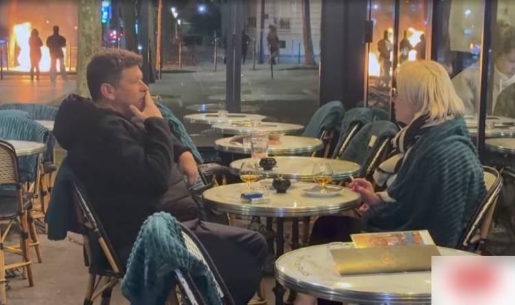 Casal aproveita drinque em café enquanto protestos tomam Paris; imagem repercute