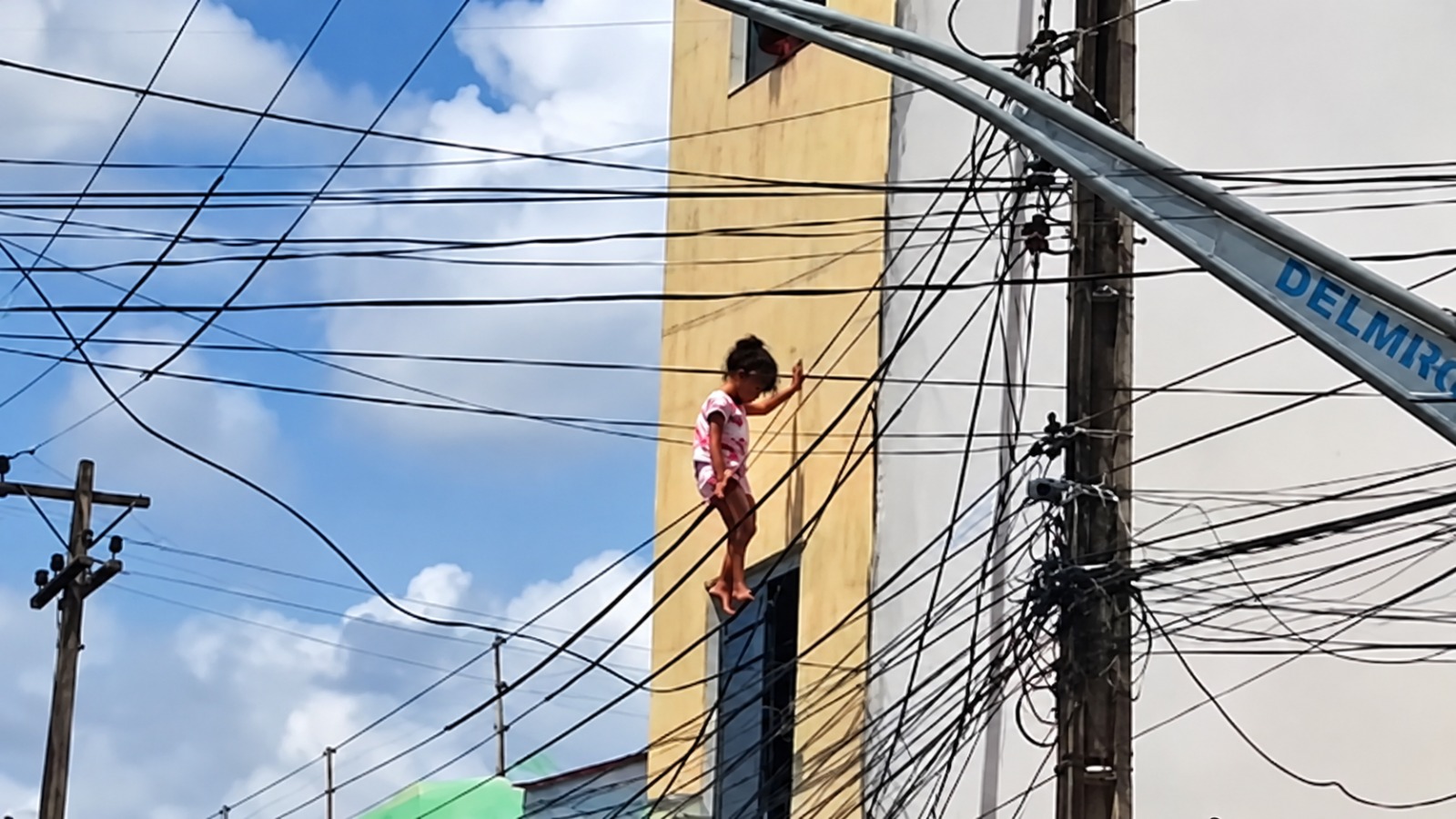 Criança cai de janela do 2º andar, fica pendurada em fiação e é salva por policial em Alagoas