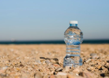 Colocar uma garrafa com água ao lado do guarda-sol: para que serve e quando usar na praia