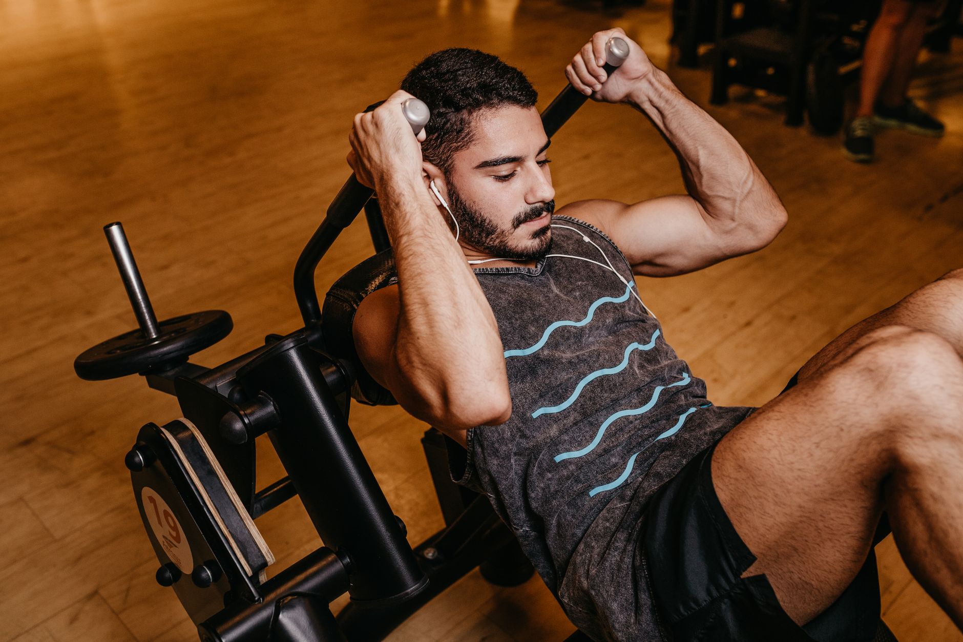 Um homem adulto malhando indoors em equipamentos de ginástica, construindo músculos e força.