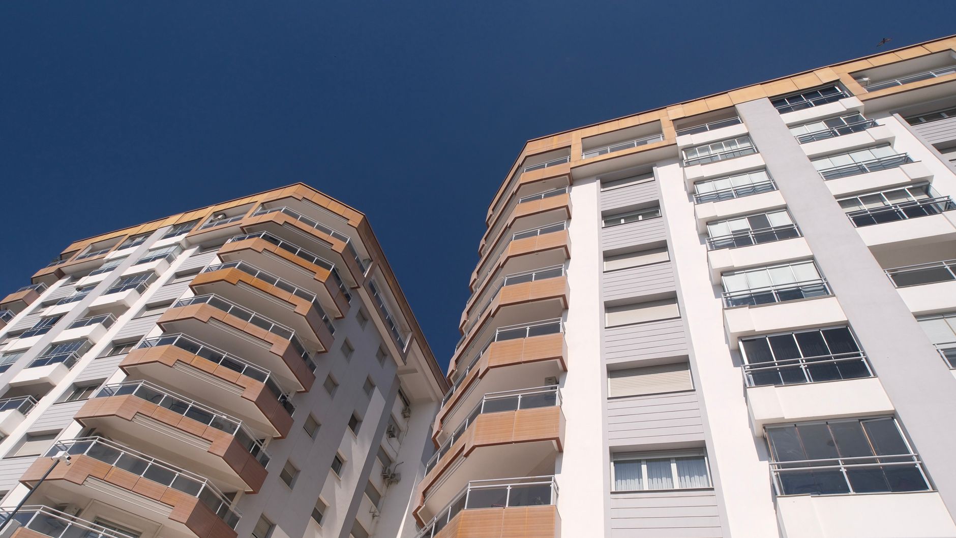 Edifícios residenciais de grande altura em Izmir, exibindo arquitetura moderna sob um céu azul límpido.