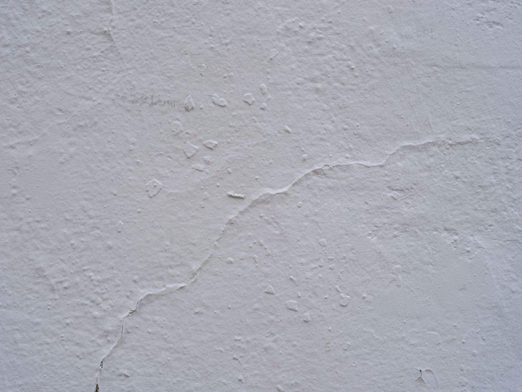 Close-up de uma parede de concreto fissurada e texturizada, ideal para fundos ou projetos de design.