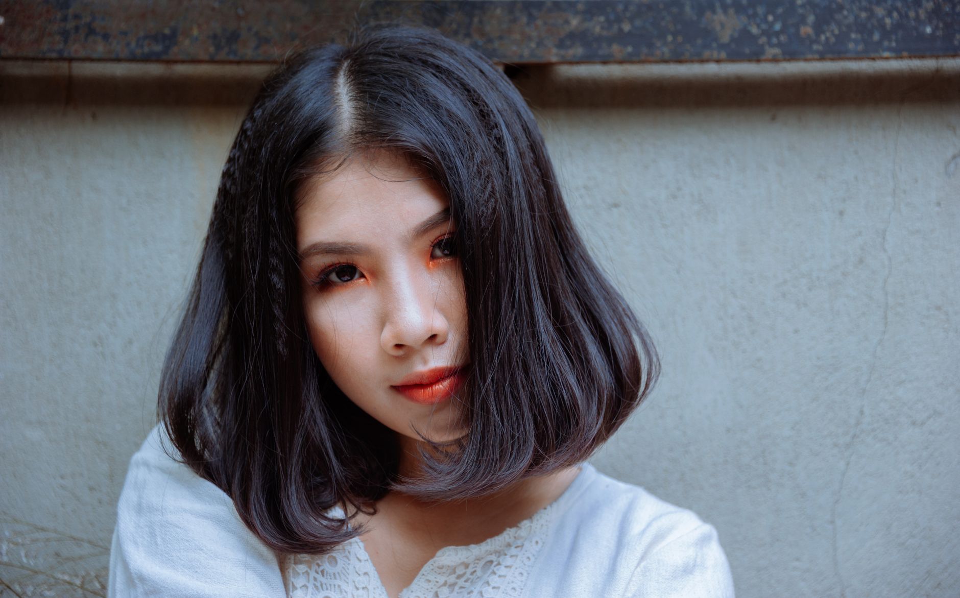 Foto em close de uma jovem mulher asiática com cabelo e maquiagem estilizados, demonstrando beleza e elegância.