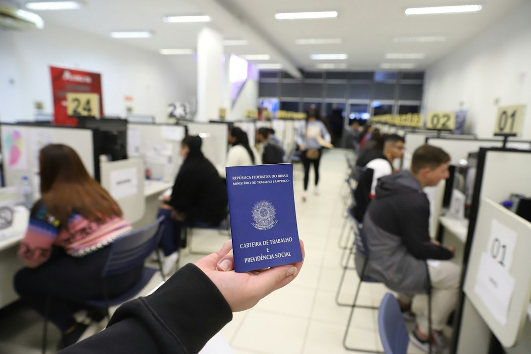 a person holding up a blue passport in an office