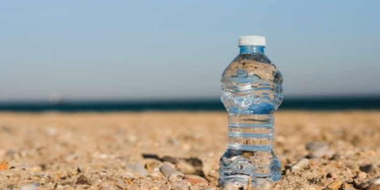 Colocar uma garrafa com água ao lado do guarda-sol: para que serve e quando usar na praia