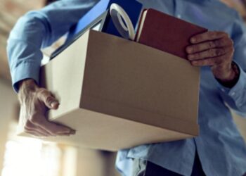 Pessoa tirando próprios pertences de uma empresa após demissão